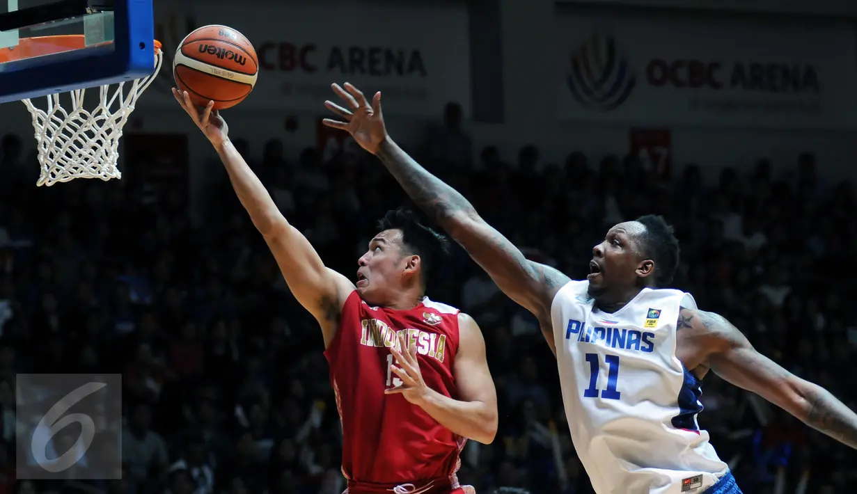 Pebasket Indonesia, Ebrahim Lopez Enguio (kiri) mencoba memasukkan bola ke jala Filipina di laga final SEA Games ke-28 di OCBC Arena Singapore, Senin (15/6/2015). Indonesia kalah 64-72 dari Filipina. (Liputan6.com/Helmi Fithriansyah) 