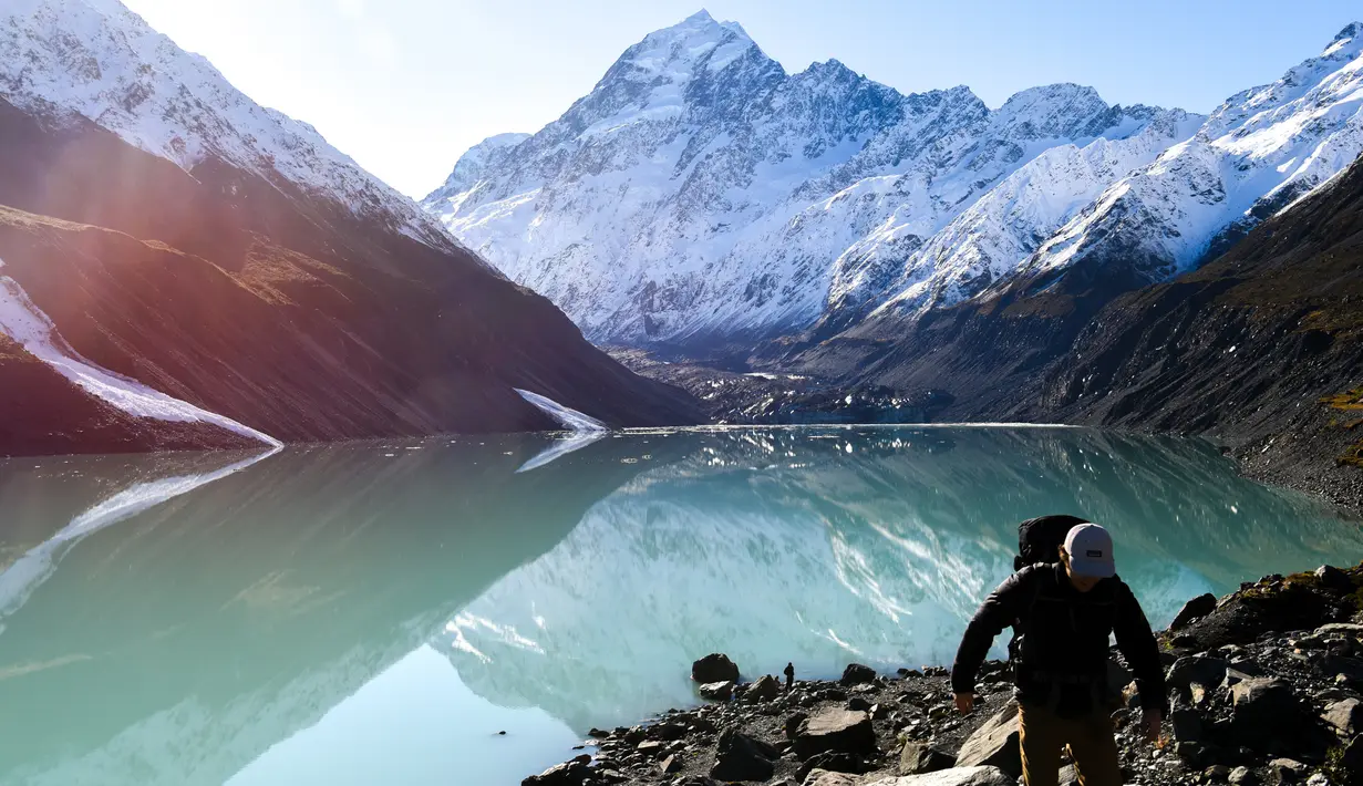 Pendaki berjalan di tepi Danau Hooker di Taman Nasional Aoraki/Mount Cook di Pulau Selatan, Selandia Baru, pada 13 Juli 2020. Aoraki Mount Cook terdiri dari 19 puncak yang berada di ketinggian setidaknya 3.000 meter di atas permukaan laut, Gletser Tasman, serta banyak danau glasial. (Xinhua/Guo Lei)