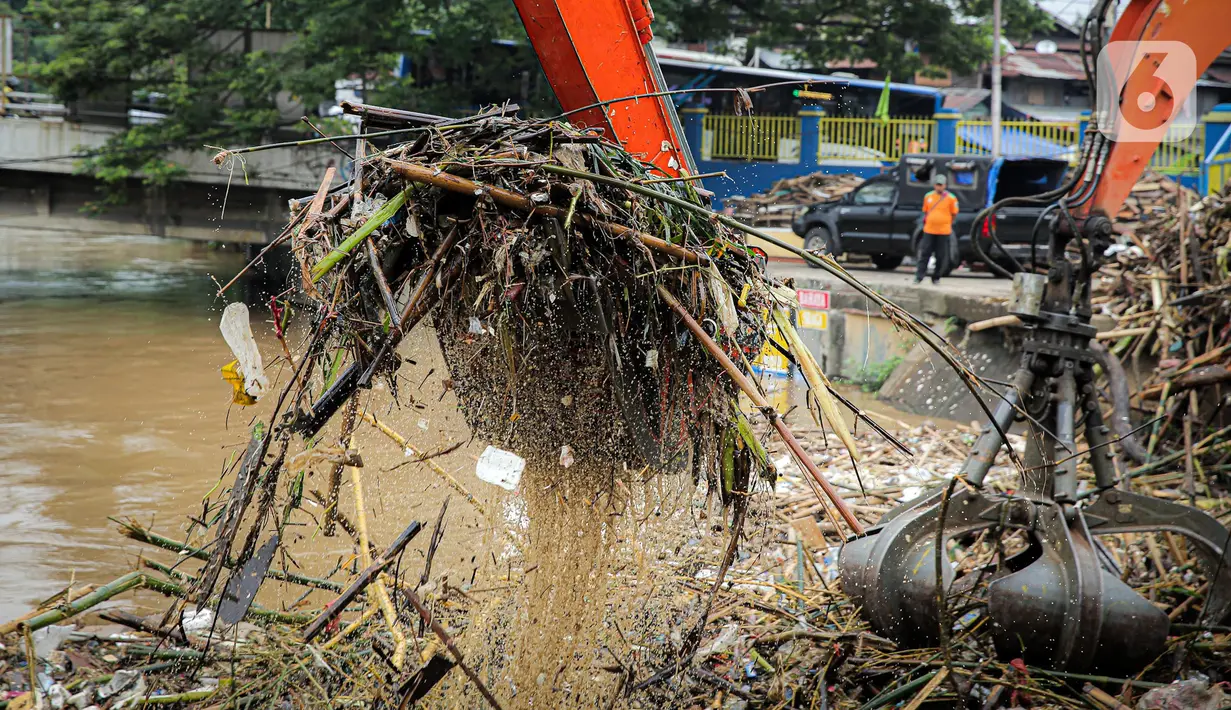 Alat berat mengeruk sampah di Pintu Air Manggarai, Jakarta, Senin (10/10/2022). Hujan lebat yang mengguyur wilayah Bogor dan sekitarnya menyebabkan debit air Sungai Ciliwung meningkat dan menghanyutkan sampah ke Pintu Air Manggarai. (Liputan6.com/Faizal Fanani)
