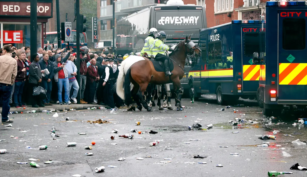 Sejumlah botol yang digunakan suporter West Ham United untuk menyerang bus skuat Manchester United berserakan di jalanan Upton Park, London, Selasa (10/5). Polisi berkuda setempat pun sempat mengadang suporter yang menyerang bus MU. (Reuters/Eddie Keogh)