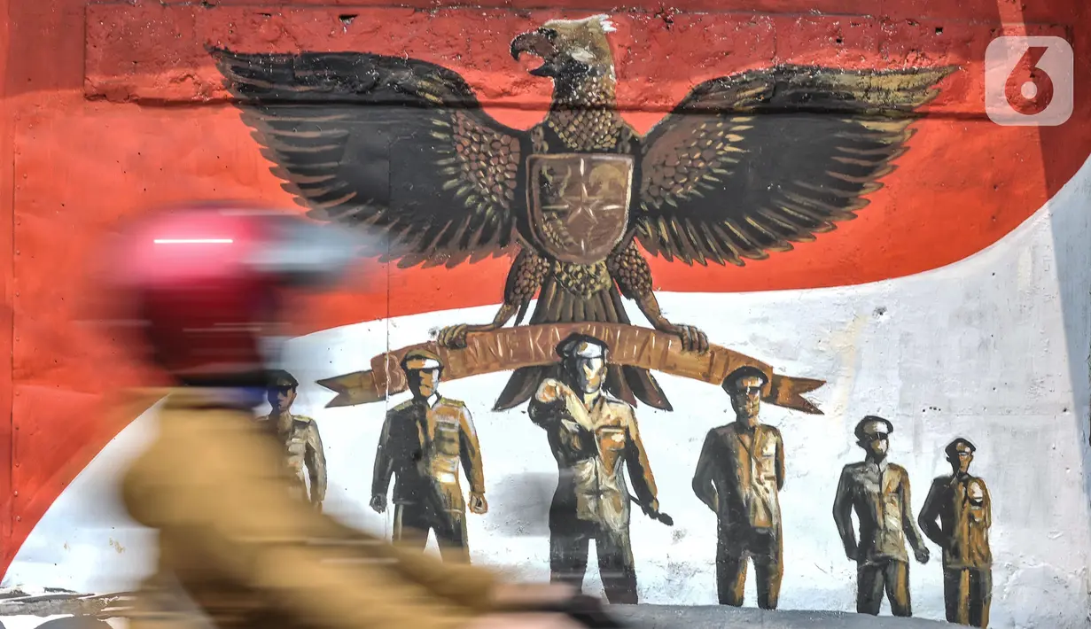 Pengendara melintas di depan mural bertemakan Pancasila di Kampung Pancasila kawasan Galur, Johar Baru, Jakarta, Selasa (1/6/2021). Mural di Kampung Pancasila ini juga untuk mempercantik lingkungan.tersebut. (merdeka.com/Iqbal S. Nugroho)
