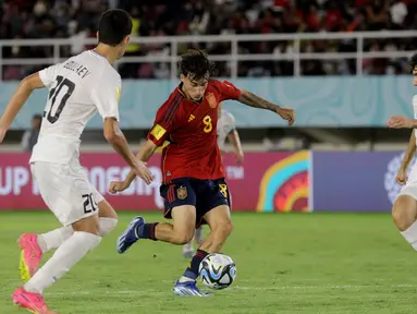 Pemain Timnas Spanyol U-17, Marc Guiu (tengah), mengontrol bola dibayangi dua pemain Timnas Uzbekistan U-17 dalam laga pamungkas Grup B Piala Dunia U-17 2023 yang berlangsung di Stadion Manahan, Solo, Kamis (16/11/2023) sore WIB. (Bola.com/Arief Bagus Prasetiyo)
