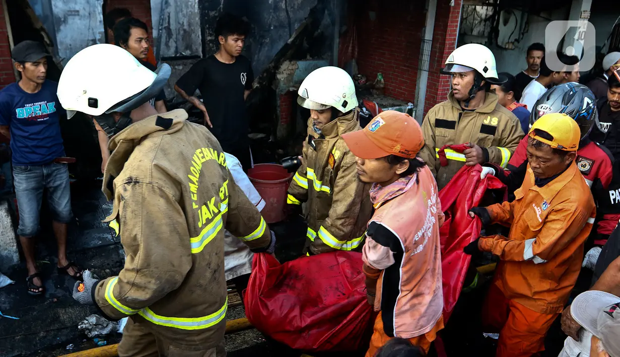 Petugas pemadam kebakaran mengevakuasi jenazah korban kebakaran di pemukiman padat penduduk kawasan Peninggaran Timur, Kebayoran Lama, Jakarta, Senin (27/1/2019). Belum diketahui penyebab terjadinya kebakaran. (Liputan6.com/Johan Tallo)