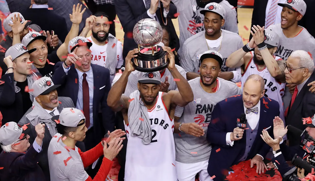 Pebasket Toronto Raptors, Kawhi Leonard, mengangkat trofi usai mengalahkan Milwaukee Bucks pada NBA Final Wilayah Timur di Scotiabank Arena, Toronto, Sabtu (25/5). Raptors menang 4-2 atas Bucks. (AFP/Claus Andersen)