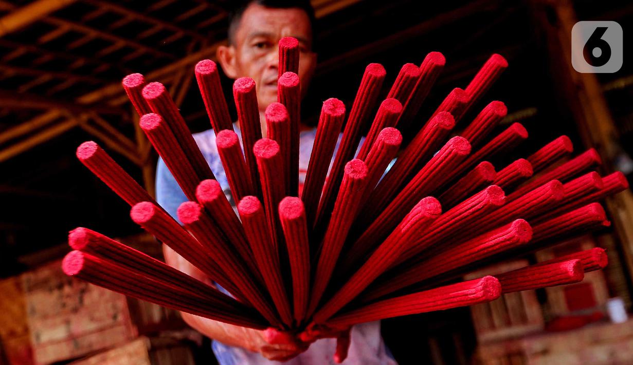 Seorang pekerja menunjukkan hio dupa di sentra industri kecil pembuatan hio di Tangerang, Banten, Senin (9/1/2023). Jelang perayaan Imlek, pesanan hio dupa mengalami peningkatan untuk kebutuhan sembahyang. (Liputan6.com/Angga Yuniar)