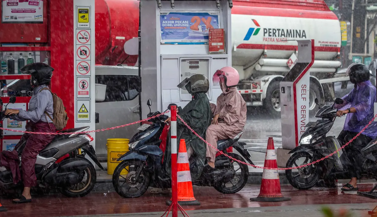Harga BBM yang mengalami kenaikan merupakan jenis nonsubsidi, dimana mengikuti perkembangan pasar minyak dunia karena adanya gelojak di Timur Tengah. Perubahan harga diprediksi terjadi per 1 April 2026 pukul 00.00 WIB. Tampak dalam foto, para pengendara sepeda motor mengantre untuk mengisi bahan bakar di sebuah Stasiun Pengisian Bahan Bakar Umum (SPBU) yang dioperasikan oleh Pertamina, perusahaan minyak dan gas milik negara Indonesia, di Yogyakarta, pada Sabtu 28 Maret 2026. (DEVI RAHMAN/AFP)