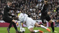 Pemain Real Madrid, Isco (tengah) jatuh saat berebut bola dengan pemain PSG, Marco Verratti (kiri) pada laga 16 besar Liga Champions di  Santiago Bernabeu stadium, Madrid, (14/2/2018).  Madrid menang 3-1. (AFP/Christophe Simon)
