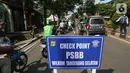 Petugas mengatur lalu lintas pada hari pertama PSBB di jalur check point Jalan Ir. H Juanda, Ciputat, Tangerang Selatan, Sabtu (18/4/2020). Status PSBB bertujuan untuk mengurangi jumlah penyebaran Covid-19 di wilayah Tangerang. (Liputan6.com/Fery Pradolo)