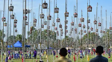 Para pria mengamati burung-burung di dalam sangkar selama kompetisi kicau burung di provinsi Narathiwat, Thailand, pada tanggal 18 September 2023. (Madaree TOHLALA/AFP)