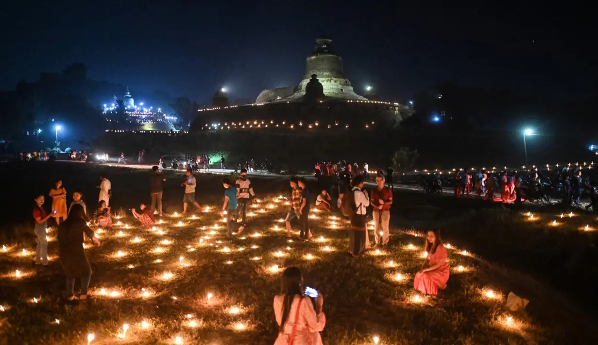 Orang-orang mengambil bagian dalam Festival Tazaungdaing di pagoda di Mrauk U, Rakhine, Myanmar, 18 November 2021. Tazaungdaing adalah Festival Bulan Purnama yang diadakan setiap tahun pada bulan purnama, bulan kedelapan dalam kalender Burma. (STR/AFP)