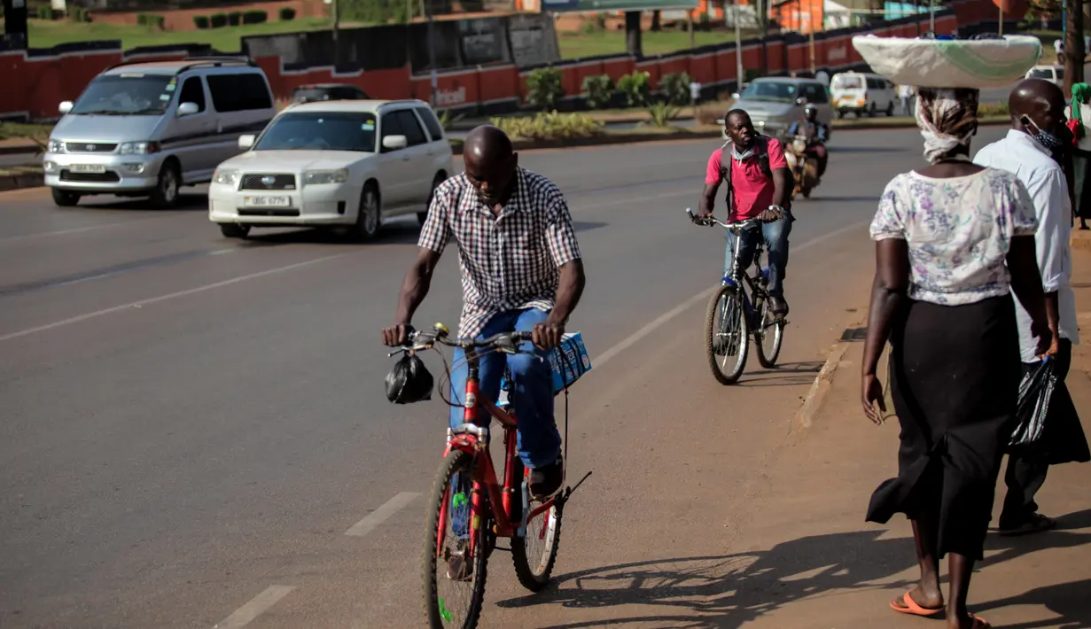 Sejumlah warga menaiki sepeda di sebuah ruas jalan di Kampala, ibu kota Uganda (30/6/2020). Warga Uganda kini beralih menggunakan sepeda sebagai sarana transportasi yang mendukung di tengah pandemi COVID-19. (Xinhua/Hajarah Nalwadda)