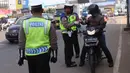 Polisi melakukan pemeriksaan pengendara motor saat pelaksanaan Pembatasan Sosial Berskala Besar (PSBB) di kawasan Gading Serpong, Tangerang Selatan, Sabtu (18/4/2020). PSBB di Tangerang Raya dalam menangani penyebaran virus corona (Covid-19) mulai berlaku sejak Hari ini. (Liputan6.com/Angga Yuniar)
