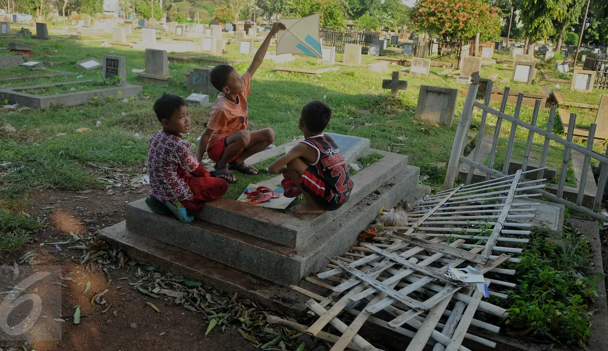 Seorang bocah bermain layang-layang di TPU Menteng Atas, Jakarta, Rabu (8/6). Wakil Gubernur DKI Jakarta Djarot Saiful Hidayat akan segera membangun Ruang Publik Terpadu Ramah Anak (RPTRA) dan Taman Pendidikan Alquran (TPA). (Liputan6.com/Gempur M Surya)