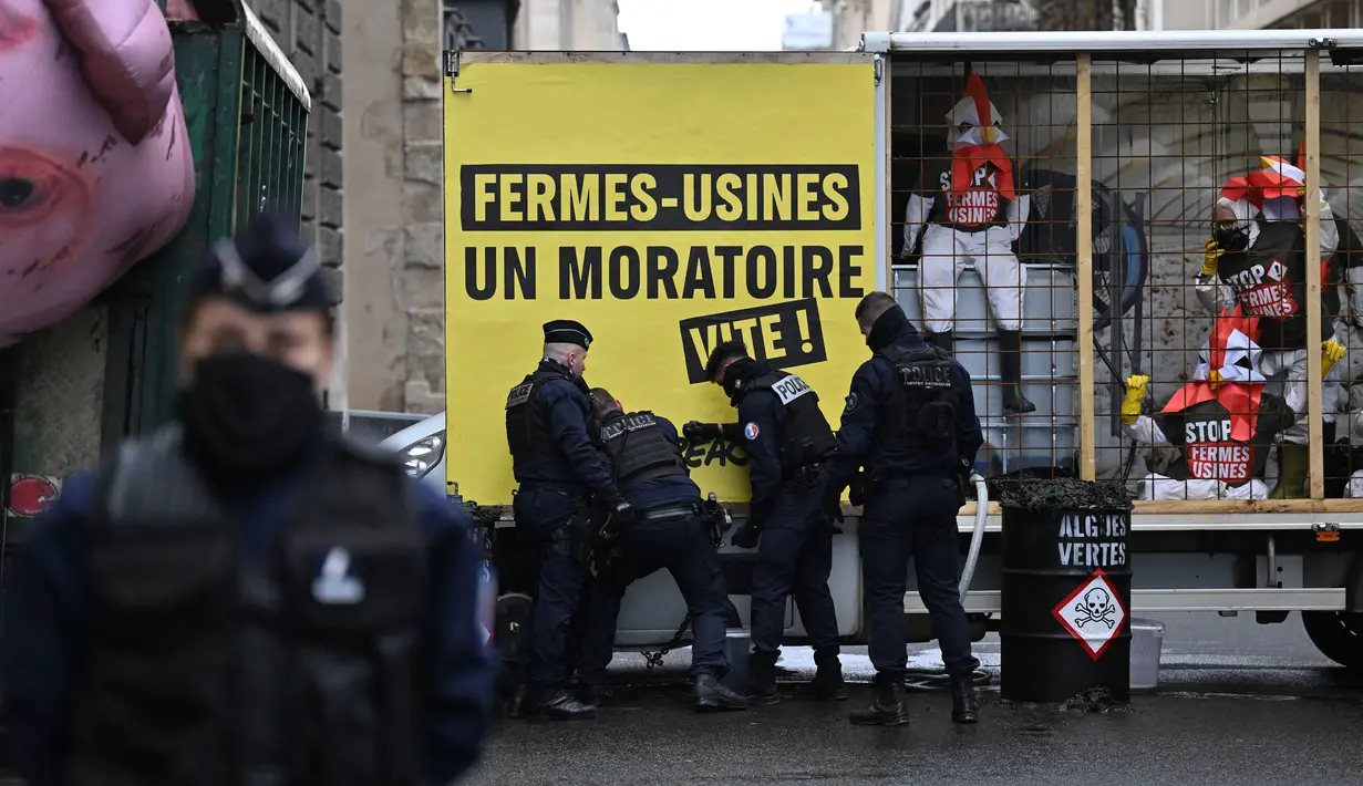 <p>Petugas polisi Prancis saat berada di lokasi di mana para aktivis Greenpeace yang memblokir jalan dengan sebuah trailer saat demonstrasi menentang kebijakan pertanian dan mengecam dampak ekologis dari pertanian industri, di dekat Kementerian Pertanian di Paris, pada tanggal 20 November 2023. (Miguel MEDINA/AFP)</p>