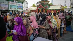 Untuk memastikan bantuan jatuh ke tangan yang tepat, pihak yayasan berkolaborasi dengan Pemerintah Kota (Pemkot) Surabaya. Tampak dalam foto, warga mengantre untuk menerima bantuan uang tunai di masjid Cheng Hoo, Surabaya, Jawa Timur pada Rabu 4 Maret 2026. (JUNI KRISWANTO/AFP)