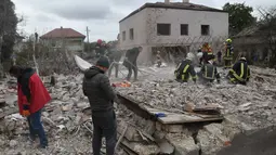 Serangan tersebut menewaskan sedikitnya lima orang dan merusak infrastruktur energi di sejumlah wilayah. Tampak dalam foto, beberapa tim penyelamat berupaya mencari korban di reruntuhan rumah yang hancur akibat serangan roket Rusia di pinggiran Lviv, Ukraina, Minggu 5 Oktober 2025. (AP Photo/Mykola Tys)