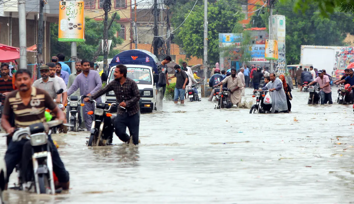 Para pengendara sepeda motor menuntun kendaraan mereka melewati banjir usai hujan monsun di Kota Karachi, Pakistan, 25 Agustus 2020. Menurut Departemen Meteorologi Pakistan, hujan monsun yang lebat pada Agustus ini memecahkan rekor sebagai curah hujan tertinggi dalam 36 tahun terakhir. (Xinhua/Str)