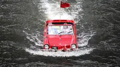 Sebuah mobil amphibi asyik berenang di sungai Mosel, Jerman dalam acara reli "Amphib 2014" (AFP PHOTO/Fredrik VON Erichse)