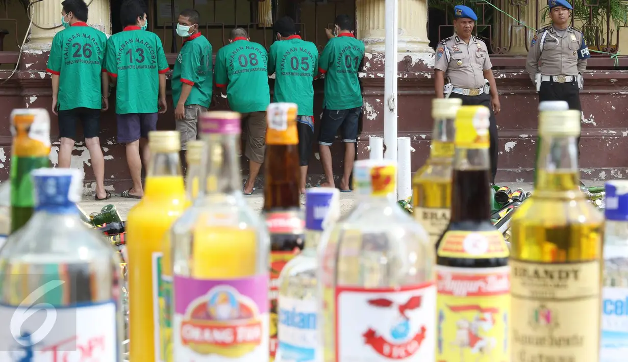 Petugas merilis tersangka dan barang bukti di Polsek Metro Palmerah, Jakarta, (22/6). Jelang Idul Fitri 1437 H, Sat Resnarkoba Polres Jakarta Barat musnahkan 10.150 botol miras, 3.597 gram shabu, dan 104 butir pil ekstasi. (Liputan6.com/Immanuel Antonius)