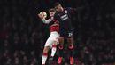 Bek Arsenal, Shkodran Mustafi, duel udara dengan striker Huddersfield, Steve Mounie, pada laga Premier League di Stadion Emirates, London, Rabu (29/11/2017). Arsenal menang 5-0 atas Huddersfield. (AFP/Ben Stansall)