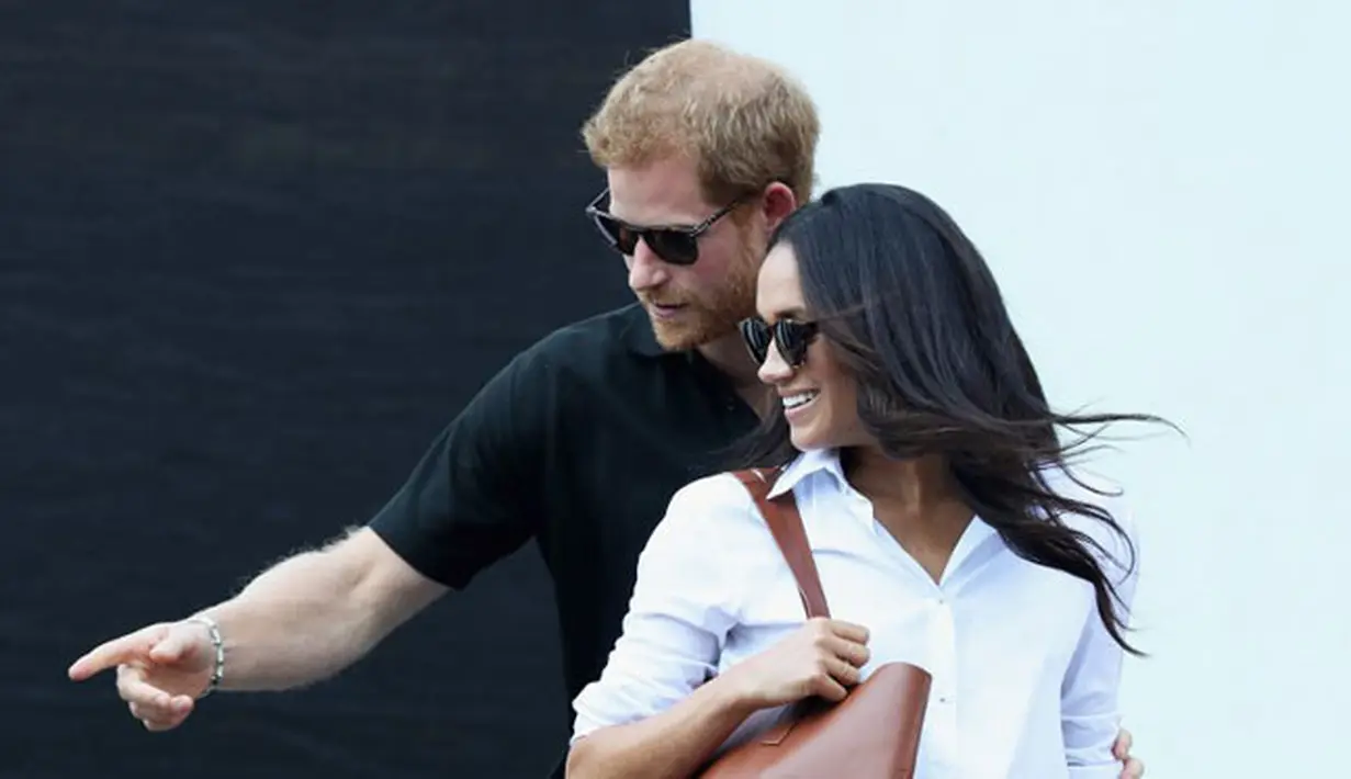 Keduanya pun sudah tak segan lagi memamerkan kemesraannya di hadapan publik. Dengan mengenakan pakaian bergaya kasual, Harry dan Meghan tak ragu untuk selalu mesra dan sesekali bergandengan tangan. (AFP/Chris Jackson)