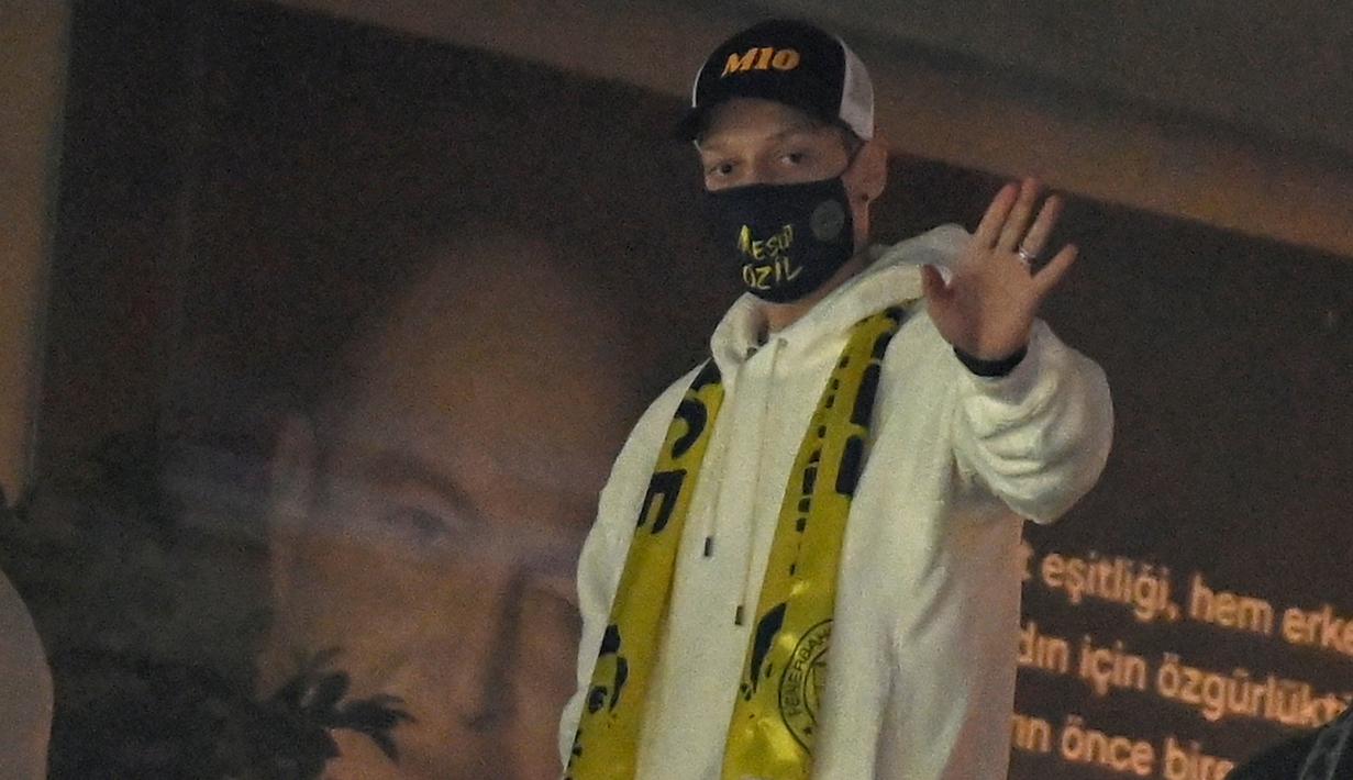 Pemain anyar Fenerbahce, Mesut Ozil melambaikan tangan saat menghadiri pertandingan timnya melawan Kaysersispor dalam lanjutan Turkish Super League di Istanbul, Senin (25/1/2021). (Foto: AFP/Ozan Kose)