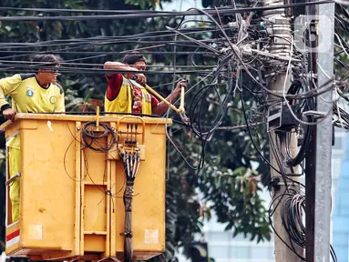 Petugas Dinas Bina Marga melakukan penertiban kabel yang menjuntai di kawasan Jakarta Barat, Rabu (2/8/2023). Imbas kecelakaan mahasiswa akibat kabel yang menjuntai, petugas melakukan penertiban kabel yang semrawut agar tidak membahayakan masyarakat. (Liputan6.com/Angga Yuniar)