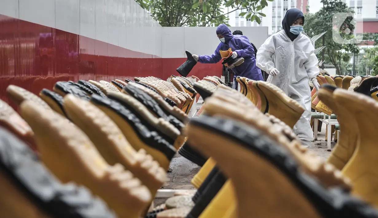 Tim Sterilisasi menjemur sepatu yang digunakan tenaga kesehatan di Rumah Sakit Darurat (RSD) Wisma Atlet Kemayoran, Jakarta. Dalam sehari Tim Sterilisasi mampu mencuci hingga 300 pasang sepatu yang telah digunakan tenaga kesehatan yang bertugas menangani pasien Covid-19. (merdeka.com/Iqbal Nugroho)