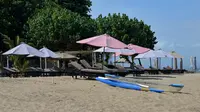 Kursi-kursi terlihat kosong di tepi pantai di Sanur, Bali, Kamis (14/10/2021). Mulai hari ini, Bali kembali dibuka untuk wisatawan mancanegara dari 19 negara di tengah pandemi COVID-19. (SONY TUMBELAKA/AFP)