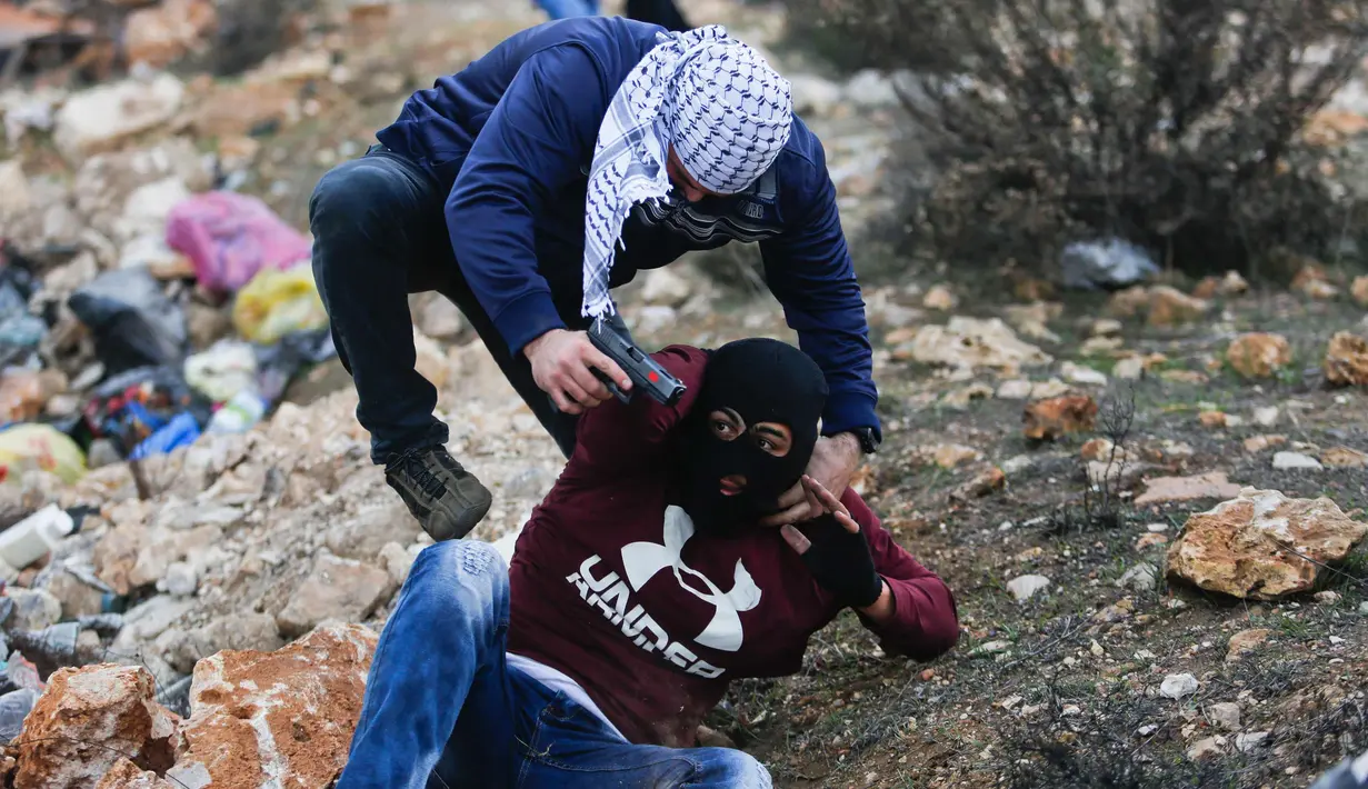 Polisi Israel menangkap seorang demonstran Palestina dalam bentrokan menyusul demonstrasi menentang keputusan Presiden AS, Donald Trump terkait Yerusalem sebagai ibu kota Israel, di kota Ramallah, Tepi Barat, (13/12). (AP Photo / Nasser Shiyoukhi)