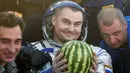 Astronaut Stasiun Luar Angkasa Internasional (ISS), Alexey Ovchinin dari Rusia memegang buah semangka setelah mendarat dengan selamat di dekat Kota Zhezkazgan, Kazakhstan, (7/9). (Bill Ingalls/NASA/Reuters)