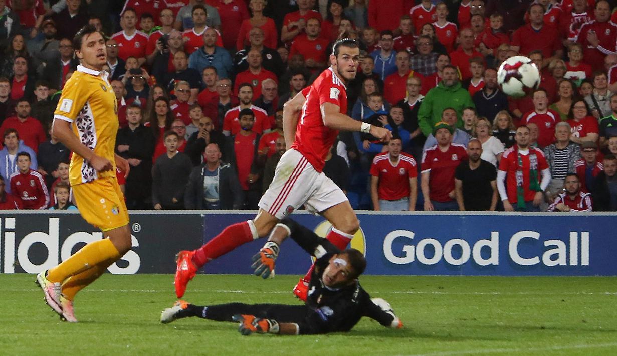 Kiper Moldova, Ilie Cebanu, hanya melihat bola yang meluncur masuk ke gawangnya lewat sepakan Gareth Bale pada Kualifikasi Piala Dunia 2018 di Stadion Cardiff City Stadium, Cardif, Wales Selatan, (6/9/2016) dini hari WIB. (AFP/Geoff Caddick)