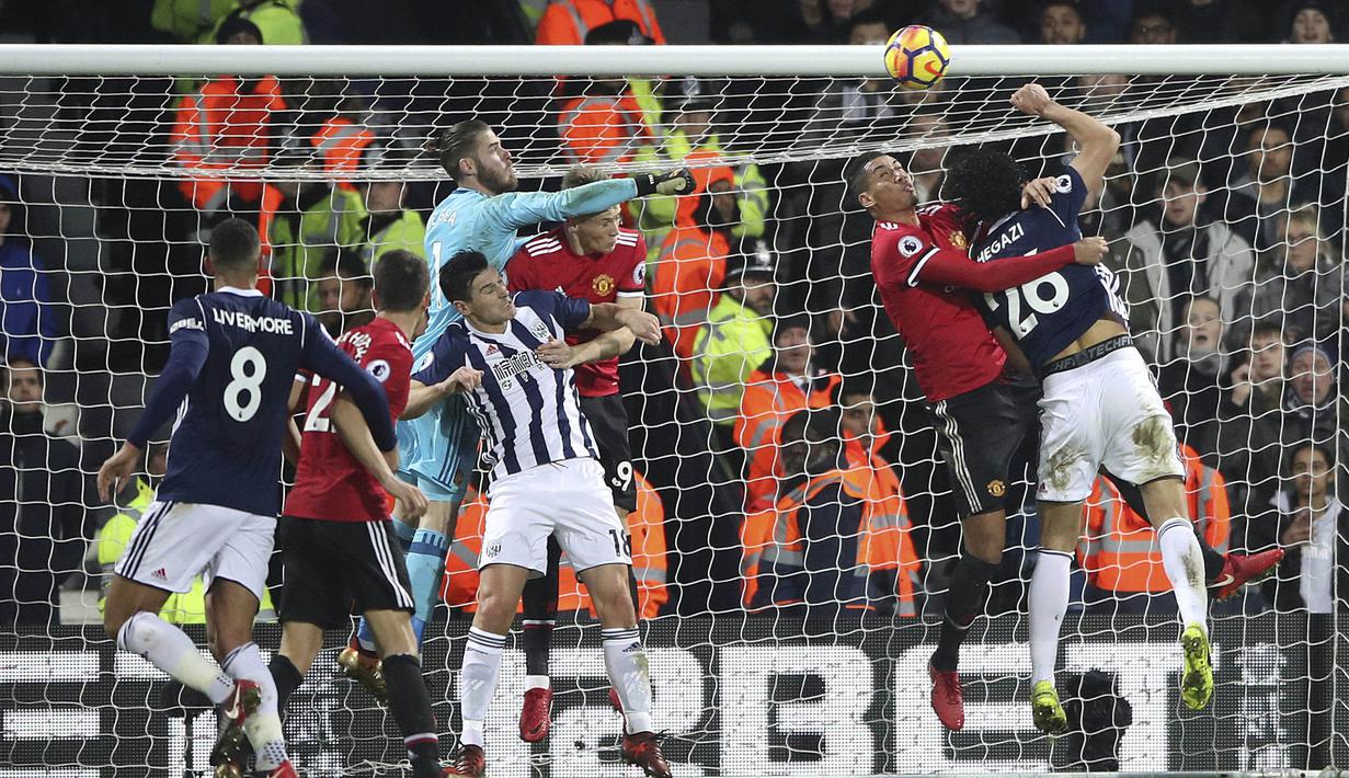 Kiper Manchester United (MU), David De Gea, berusaha meninju bola saat melawan West Bromwich Albion (WBA) pada laga Premier League di Stadion The Hawthorns, Minggu (17/12/2017). MU menang 2-1 atas WBA. (AP/Nick Potts)