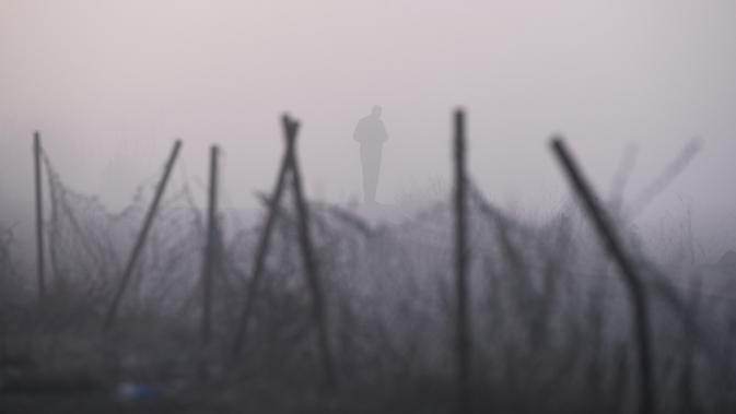 Seorang pria berjalan saat kabut tebal melanda kota Pristina (17/12/2019). Selama beberapa bulan terakhir Pristina terdaftar sebagai salah satu kota yang mengalami kualitas udara terburuk di dunia. (AFP/Armend Nimani)