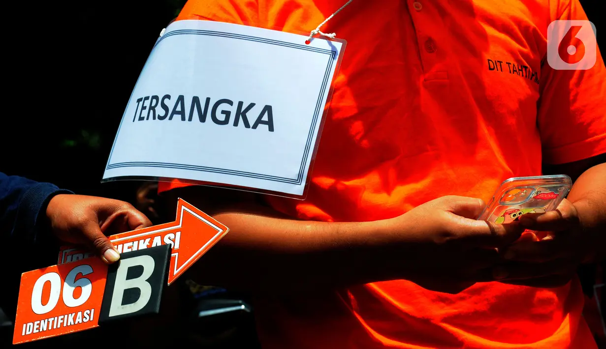 Anggota Densus 88 Bripda Haris Sitanggang alias Bripda HS menjalani salah satu adegan saat rekonstruksi pembunuhan sopir taksi online Sony Rizal Taihitu (56) di lapangan Direktorat Reserse Kriminal Umum Polda Metro Jaya, Jakarta, Kamis (16/2/2023). Bripda HS menjalani 37 adegan sebagai rangkaian peristiwa pembunuhan Sony Rizal Taihitu di Jalan Nusantara Perumahan Bukit Cengkeh, Kelurahan Tugu Cimanggis, Depok, Jawa Barat. (merdeka.com/Imam Buhori)
