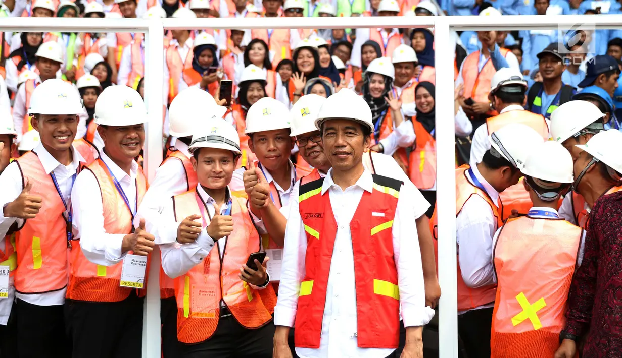 Presiden Joko Widodo (Jokowi) berfoto bersama para pekerja konstruksi di Stadion GBK, Jakarta, Kamis (19/10). Jokowi akan menyaksikan sertifikasi 9.700 tenaga kerja konstruksi di seluruh Indonesia secara serentak. (Liputan6.com/Angga Yuniar)