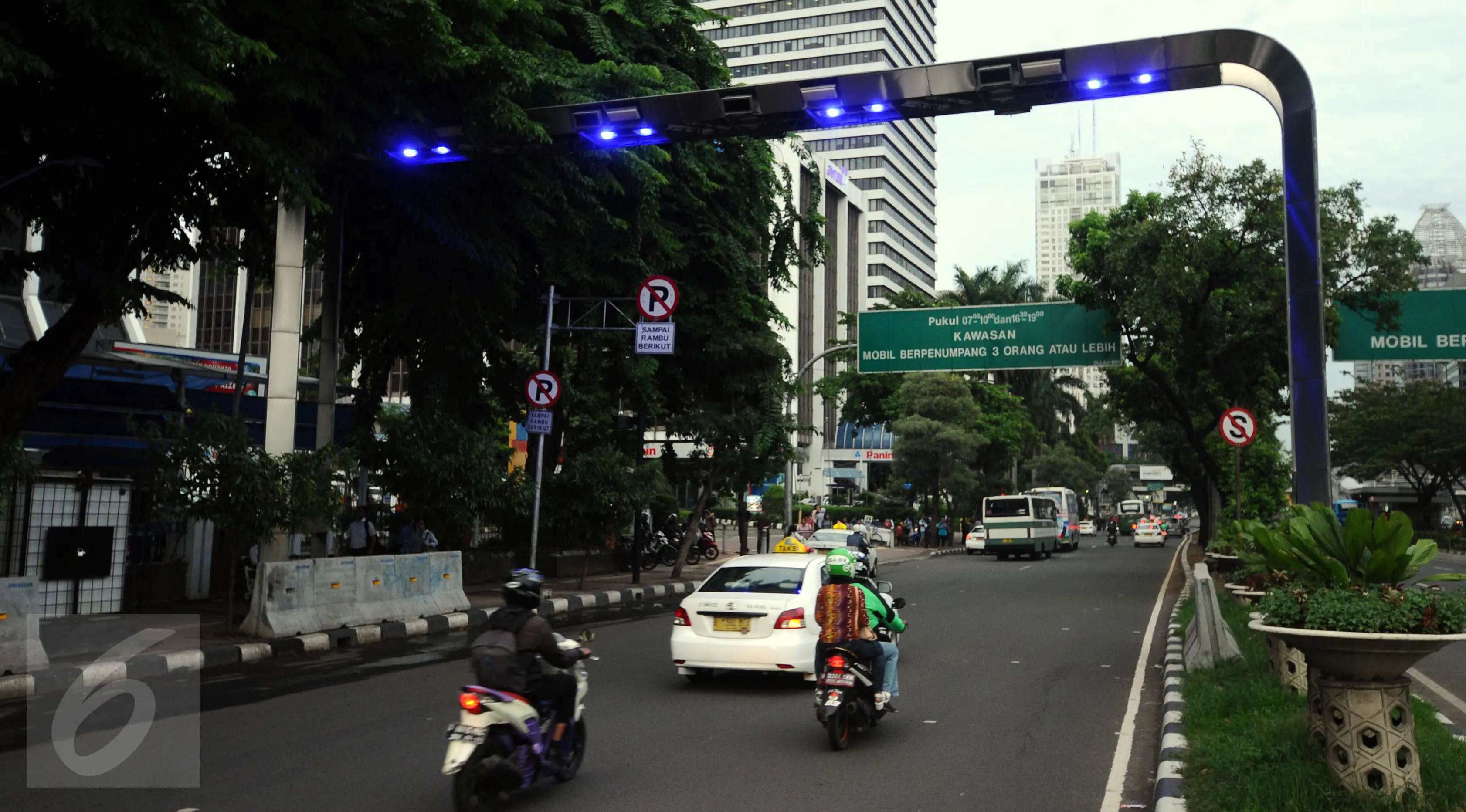 Pengendara melintas di bawah gate ERP di Jalan Jenderal Sudirman Jakarta, Senin (14/12). Meski sudah diuji coba pada pertengahan 2014 lalu, hingga kini penerapan jalan berbayar tersebut masih belum jelas. (Liputan6.com/Helmi Fithriansyah)