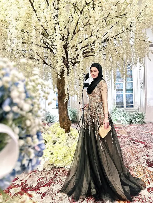 Inara Rusli memancarkan pesona glamor dalam balutan maxi dress berhias bordiran bunga dan payet nuansa emas-hitam. [@mommy_starla].