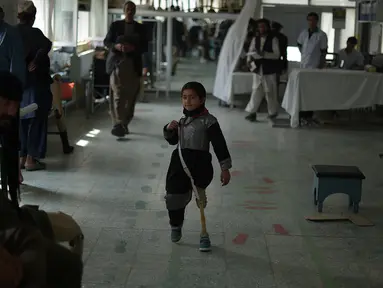 Seorang gadis kecil Afghanistan berjalan menggunakan kaki palsu di pusat ortopedik Komite Internasional Palang Merah (ICRC), rumah sakit bagi korban perang dan yang diamputasi, di Kabul, Minggu (3/4).  (SHAH Marai/AFP)