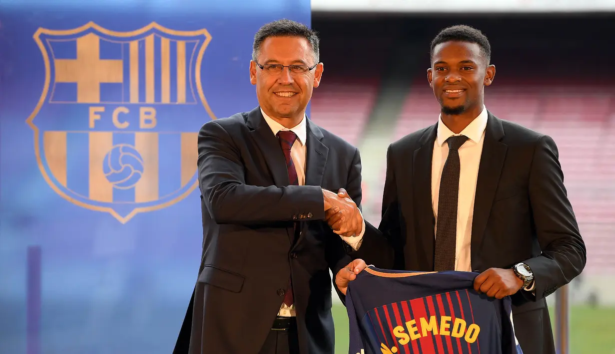 Presiden Barcelona, Josep Maria Bartomeu, foto bersama dengan bek barunya, Nelson Semedo, di Stadion Camp Nou, Katalonia, Jumat (14/7/2017). Pemain 23 tahun itu didatangkan dari Benfica dengan harga 26,2 juta poundsterling. (AFP/Lluis Gene)