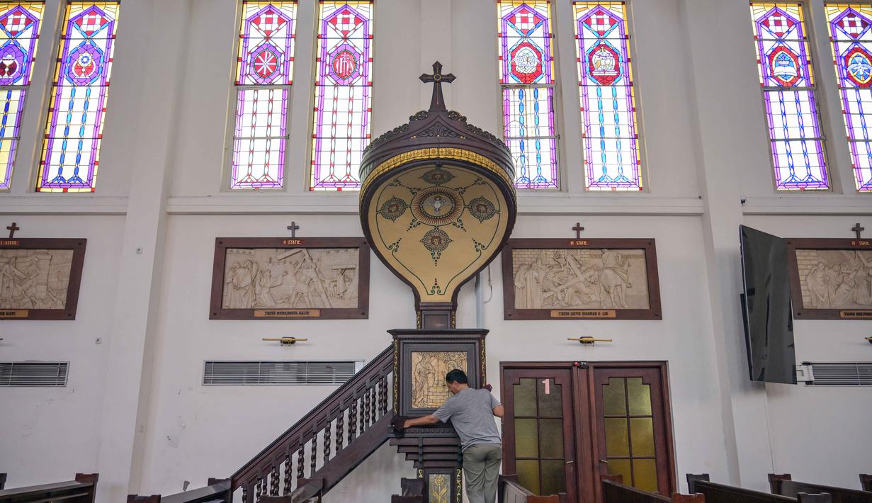 Seorang pekerja membersihkan mimbar di Katedral Hati Kudus Yesus, yang dikenal secara lokal sebagai gereja "Hati Kudus Yesus", selama persiapan Misa Natal di Surabaya, Jawa Timur, pada Selasa 23 Desember 2025. Jelang Misa Natal 2025, Katedral Hati Kudus Yesus atau yang dikenal secara lokal sebagai Gereja Katolik Hati Kudus Yesus di Surabaya, Jawa Timur, telah melakukan berbagai persiapan. (JUNI KRISWANTO/AFP)