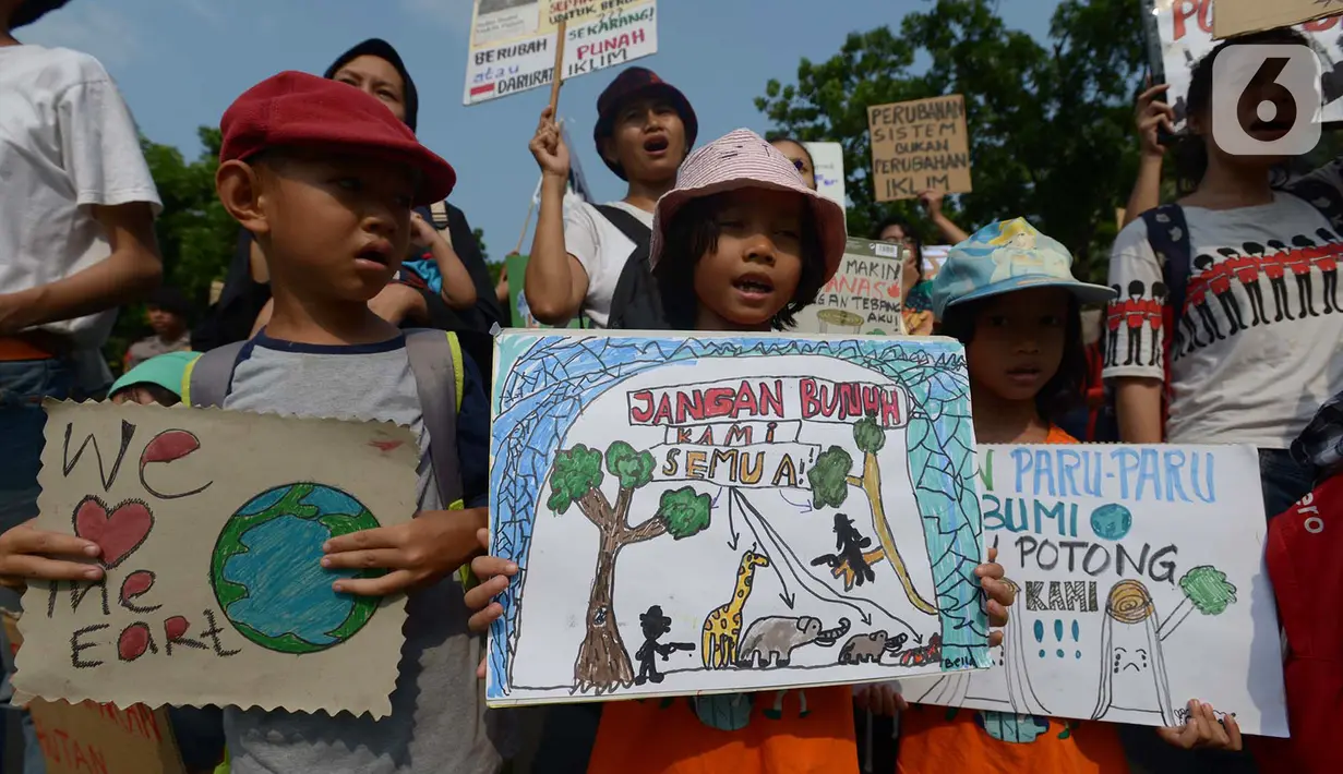 Anak-anak membawa spanduk bertuliskan pesan saat aktivis lingkungan hidup dari berbagai LSM berjalan kaki menuju Taman Aspirasi di Istana Merdeka, Jakarta, Jumat (29/11/2019). Aktivis meminta pemerintah segera mendeklarasikan perubahan iklim yang semakin kritis. (merdeka.com/Imam Buhori)