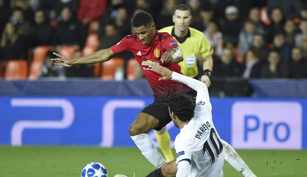 Gelandang Man United, Marcus Rashford berusaha melewati gelandang Valencia, Daniel Parejo pada laga terakhir grup H Liga Champions yang berlangsung di stadion Mestalla, Valencia, Rabu (13/12). Manchester United kalah 1-2 atas Valencia. (AFP/Jose Jordan)