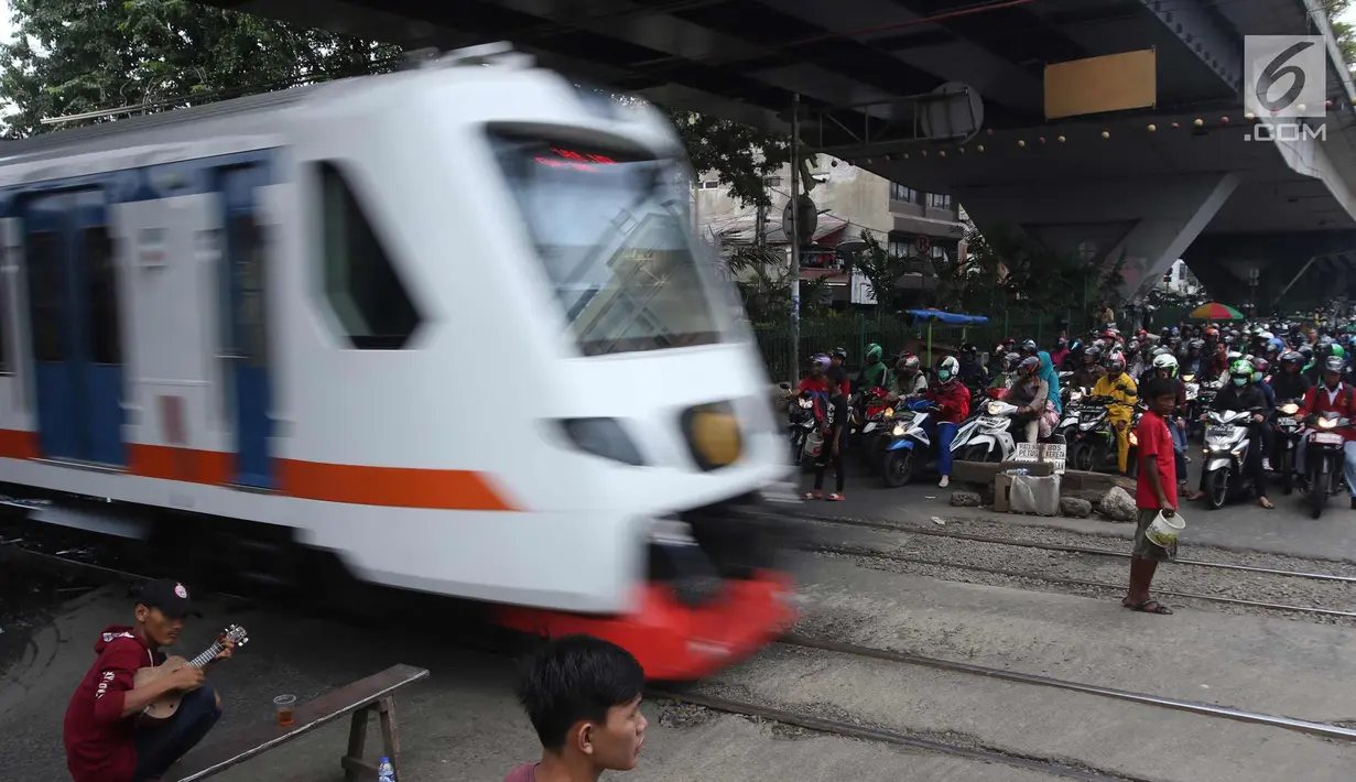 Kereta melintas di perlintasan kereta api yang tidak berpalang pintu di kawasan Roxy, Jakarta, Rabu (21/3). Pembukaan celah untuk akses sepeda motor di pintu perlintasan kereta api tersebut sangat membahayakan. (Liputan6.com/Arya Manggala)