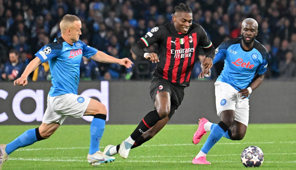 Pemain AC Milan, Rafael Leao, berusaha melewati pemain Napoli pada laga babak perempat final leg kedua di Stadio Diego Armando Maradona, Rabu (19/4/2023). AC Milan berhasil meraih hasil imbang 1-1 di markas Napoli. (AFP/Alberto Pizzoli)