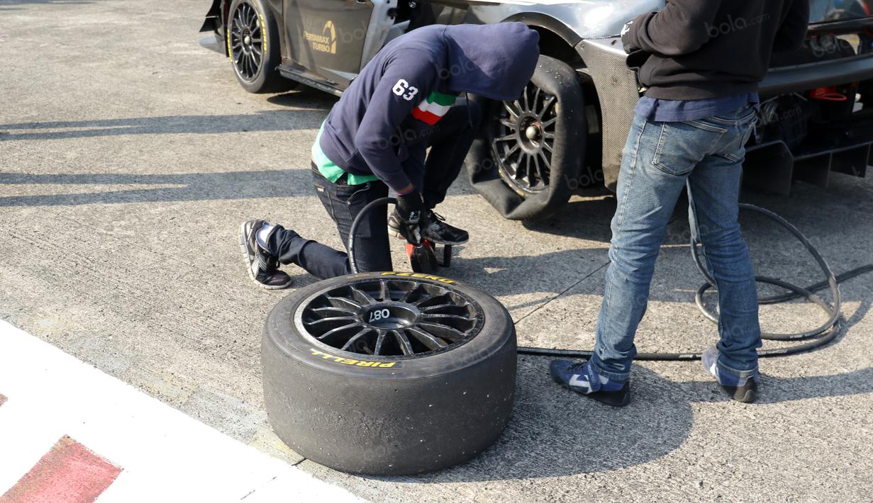 Teknisi sedang mengganti ban mobil Lamborghini yang bocor sebelum dikendarai Sean Gelael  pada ajang Taxi Ride di Sentul, Jakarta, Selasa (2/8/2016). (Bola.com/Nicklas Hanoatubun)