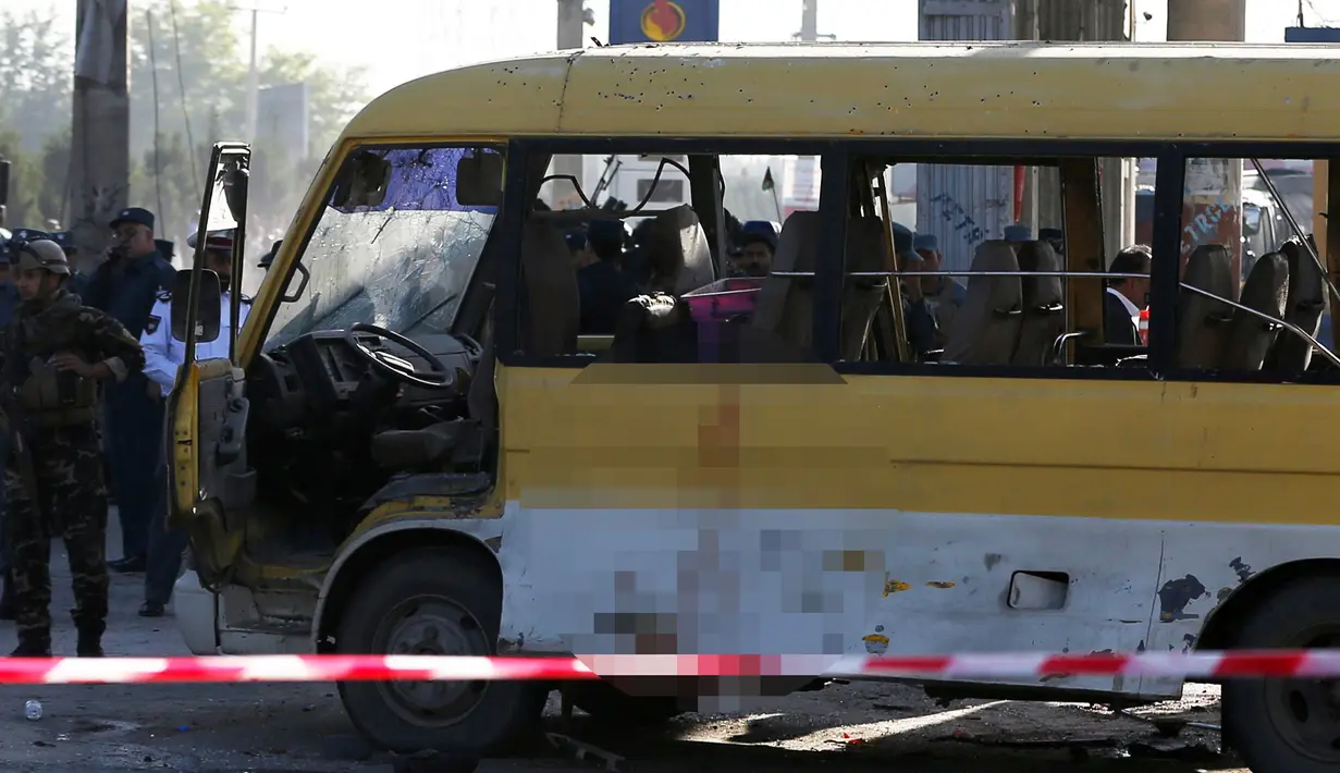 Petugas keamanan dan pemadam kebakaran saat mengecek kondisi minibus yang terkena serangan bunuh diri di Kabul, Afghanistan, Senin (20/6). Sebanyak 14 orang tewas akibat serangan ini. (REUTERS / Omar Sobhani)