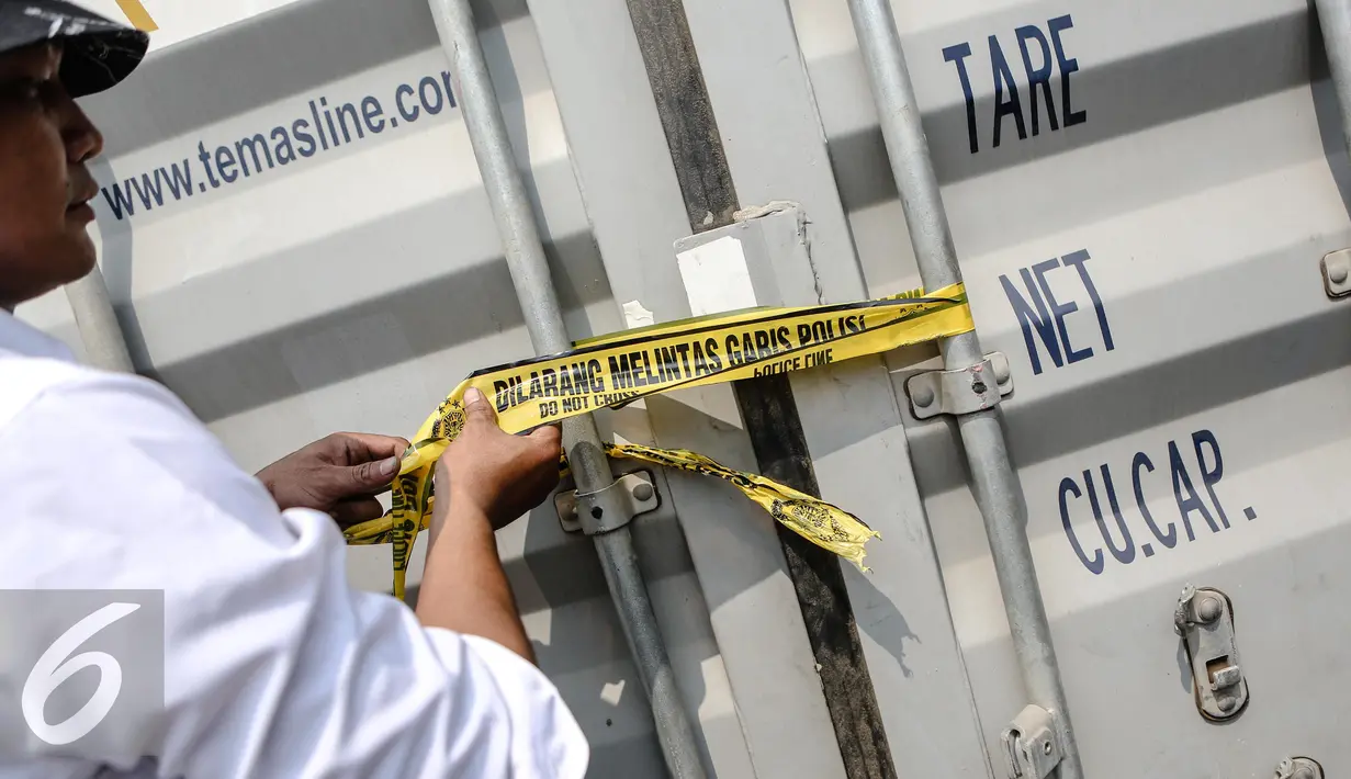 Petugas menyegel kontainer berisi produk illegal di Pelabuhan Tanjung Priok, Jakarta, Senin (6/7/2015). Badan POM RI menyita 8 kontainer produk pertanian dan kosmetik ilegal dengan nilai Rp 13,5 miliar. (Liputan6.com/Faizal Fanani)