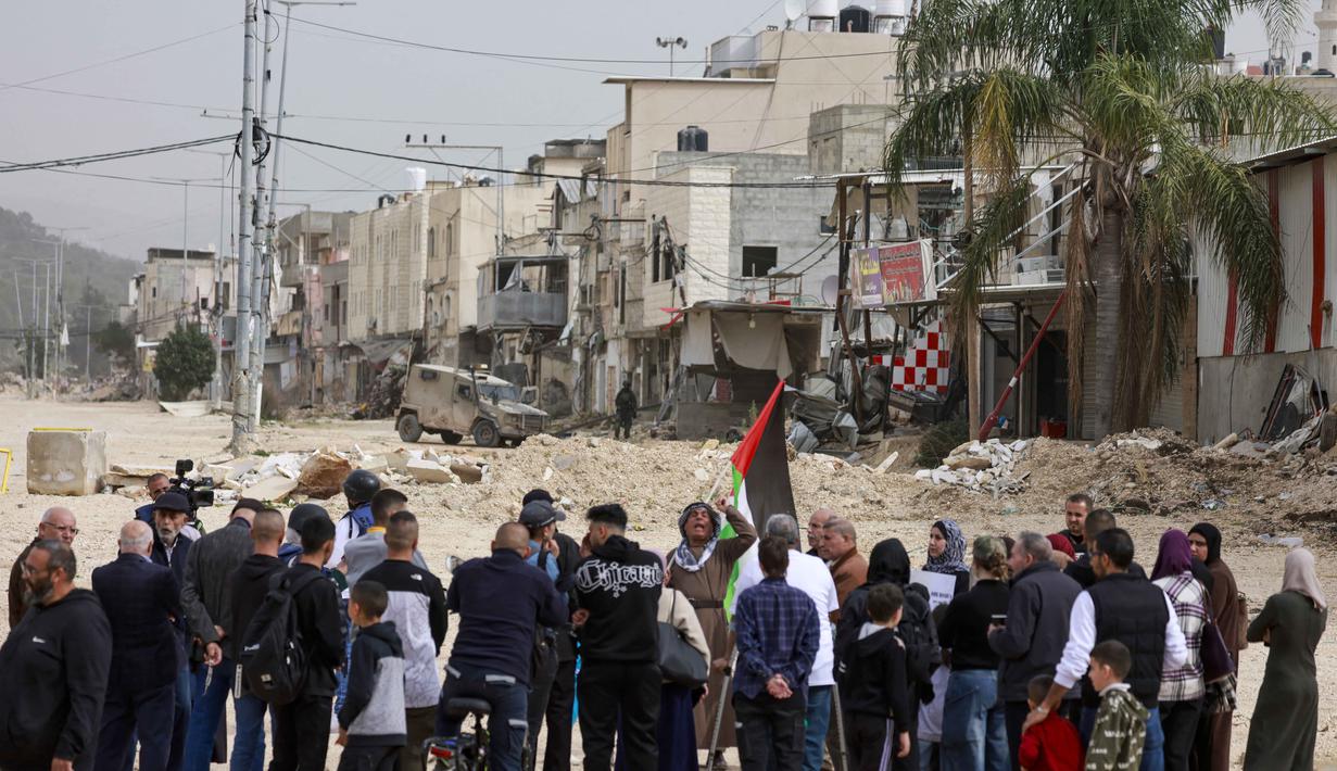 Diketahui, Israel telah memperluas penutupan militer dan blokade terhadap Kamp Pengungsi Nur Shams di Tepi Barat hingga 31 Maret 2026. Tampak dalam foto, warga Palestina berunjuk rasa setelah tentara Israel memblokir pintu masuk kamp pengungsi Palestina Nur Shams di Tepi Barat yang diduduki pada Senin 9 Februari 2026. (Jaafar ASHTIYEH/AFP)