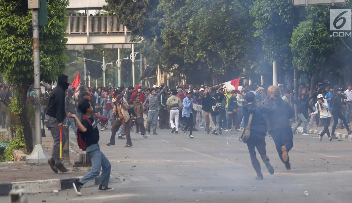 Pelajar melempari Gedung DPR dengan batu saat berunjuk rasa di Palmerah, Jakarta, Rabu (25/9/2019). Pihak kepolisian menembakan gas air mata untuk memukul mundur pelajar. (Liputan6.com/Angga Yuniar)